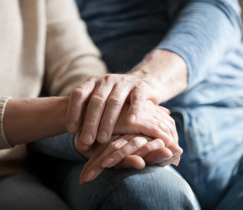 A close-up photo of one person holding another's hands