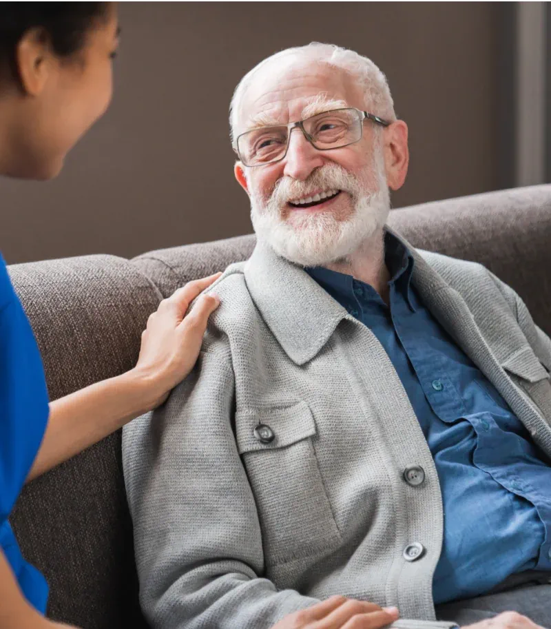 Photo of a nurse touching an elderly man's shoulder
